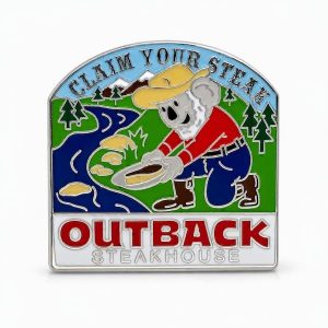 Outback‑themed ‘Claim Your Steak’ pin showing a bearded koala in jeans and work boots, styled like a gold prospector by a river while holding a steak plate, with bold western font