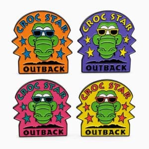 “Croc Star” lapel pins in four colors—orange, purple, pink, and yellow—each featuring a cartoon crocodile wearing sunglasses.”