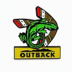 Cartoon gecko perched on a boomerang in an Outback‑style design, shown with the Outback logo beneath.