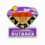 "I rock" lapel pin with iconic Australian rock landscape and purple sky, with a boomerang and Australian silhouette