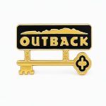 Outback‑themed pin showing the Outback logo with a key hanging below, representing the "Key" role which is focused on supporting front‑of‑house staff, upholding restaurant standards, and ensuring strong internal communication.