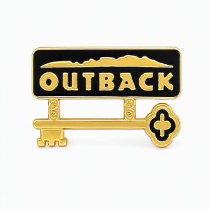 Outback‑themed pin showing the Outback logo with a key hanging below, representing the "Key" role which is focused on supporting front‑of‑house staff, upholding restaurant standards, and ensuring strong internal communication.