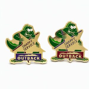 Two lapel pins with slight color variations featuring a croc behind a star with the phrase 'Snappy Service' and the Outback logo, created by The Pin Center