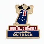 Lapel pin of a Kangaroo showing off his Australian flag cape with the phrase "True Blue Trainer" and the Outback logo, created by The Pin Center