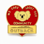 Heart shaped lapel pin with a koala saying "we care about our community" and the Outback logo, created by The Pin Center